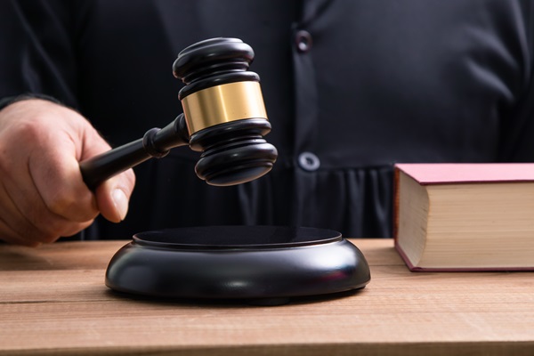 Judge's hand holding a gavel, passing down a sentence for a criminal conviction.
